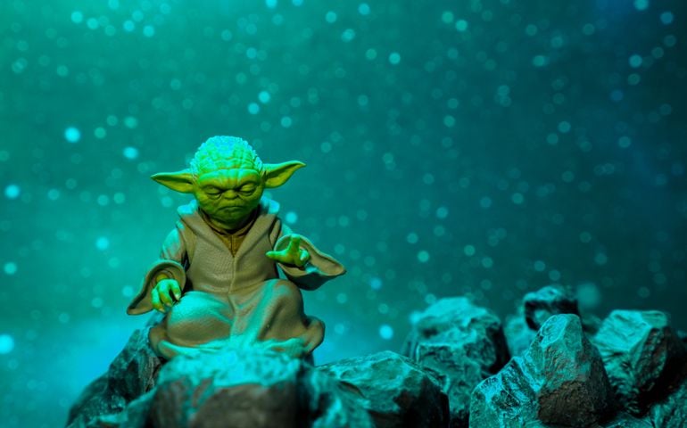Master Yoda, an action figures, sitting on the rock with snowing background