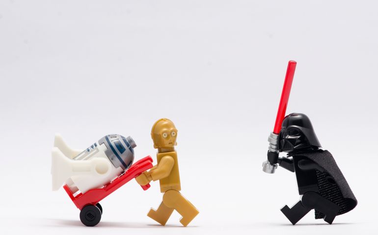 darth vader chasing c3po with r2d2 sitting on trolley