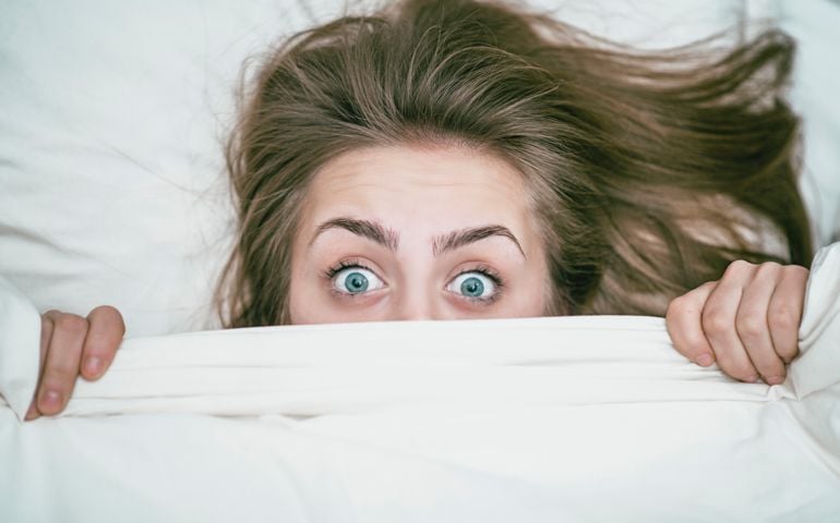 Female with Blue Eyes Covered with White Blanket