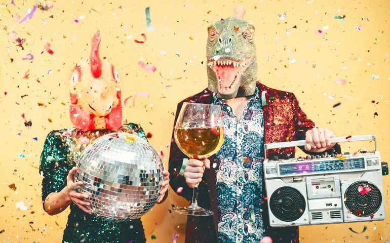 Crazy couple celebrating new year eve wearing chicken and dinosaur t-rex mask - Young trendy people having fun drinking champagne and listening music with vintage boombox - Absurd and holidays concept