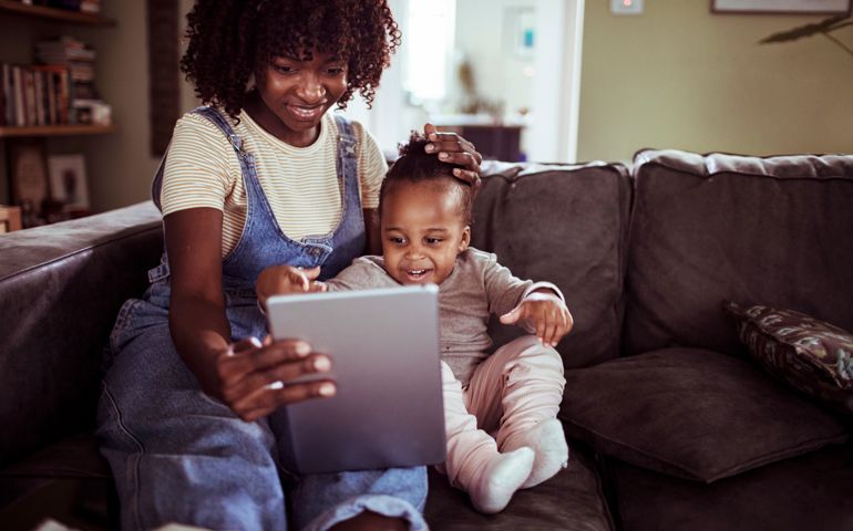 Close up of a mother and daughter using a tablet at home
