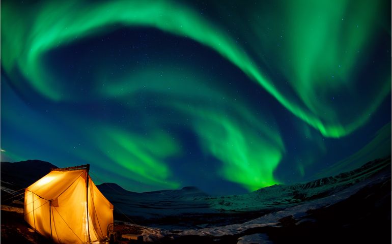 Camping in the north with the northern lights overhead (Aurora Borealis)