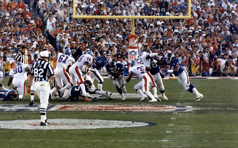 PASADENA, CA - JANUARY 25: Quarterback Phil Simms #11 of the New York Giants hands the ball off to Joe Morris #20 during Super Bowl XXI against the Denver Broncos on January 25, 1987 in Pasadena, California.