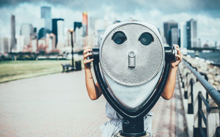 Little girl Looking through coin operated binoculars in New York City.