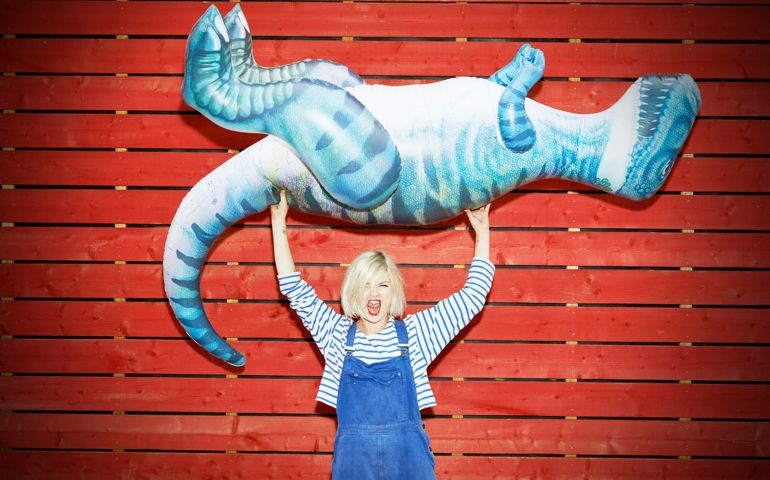 woman holding up toy dinosaur