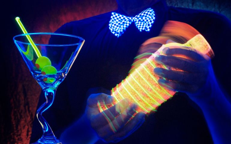 Bartender shaking a glowing cocktail shaker
