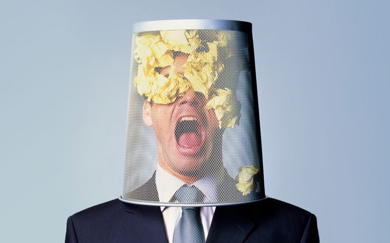 Shot of a businessman with a waste paper bin on his head