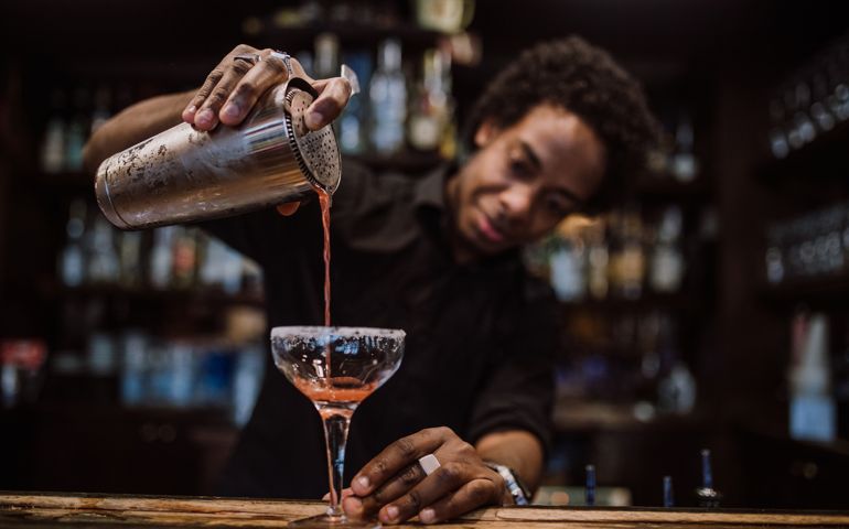 Barman is making cocktail at night club
