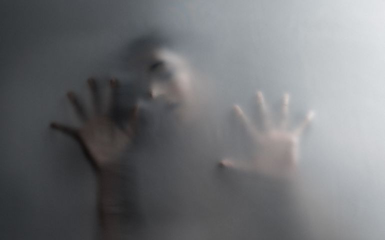 Cropped shot of an unrecognizable woman trapped behind a hazy film