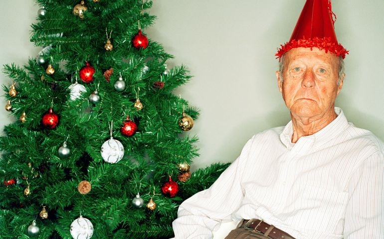 Elderly man beside Christmas tree, portrait