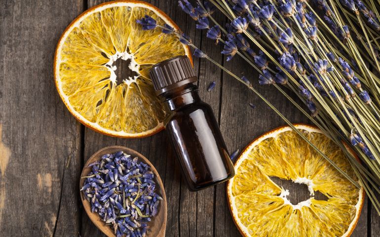 Essential oil lavender and orange dry on a wooden table, top view