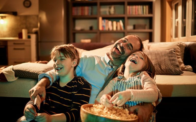 Close up of a father watching television with his kids