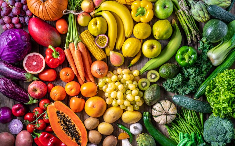 Colorful vegetables and fruits vegan food in rainbow colors arrangement full frame