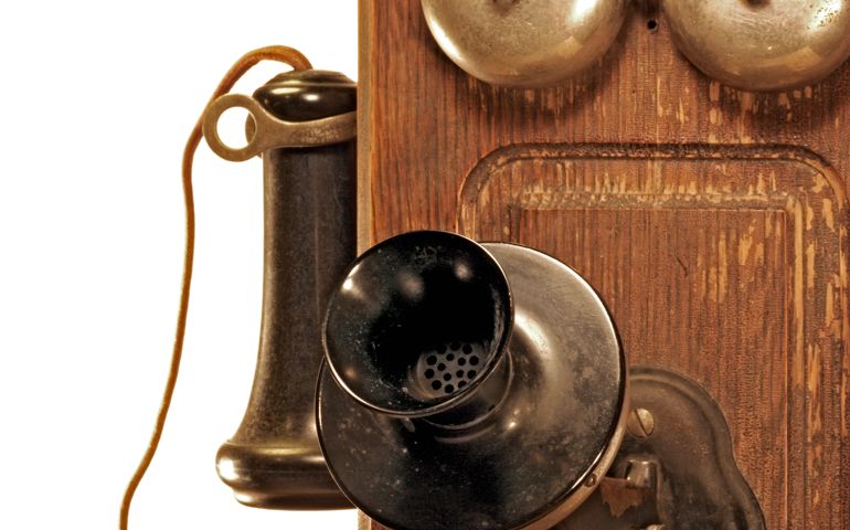Closeup of an antique crank telephone isolated on white.