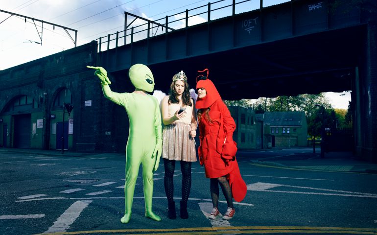 friends in fancy dress checking mobile for map