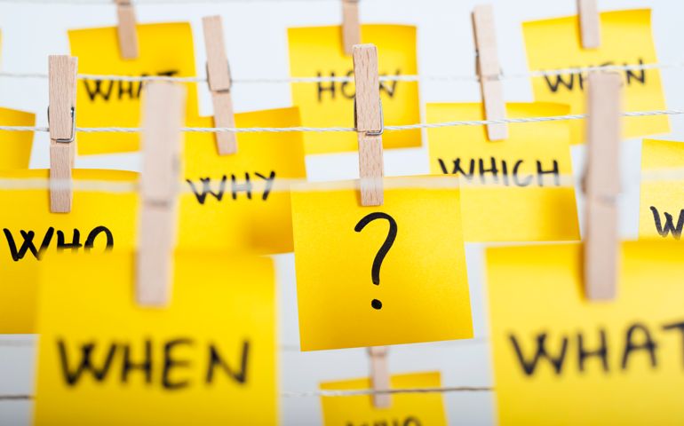adhesive note papers with question mark and w questions hanging on the rope
