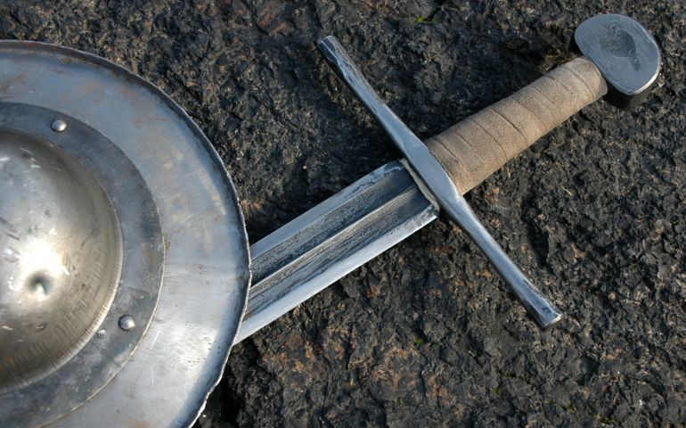 rough forged medieval sword with small shield