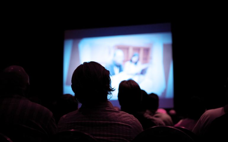 People watching movie in dark cinema