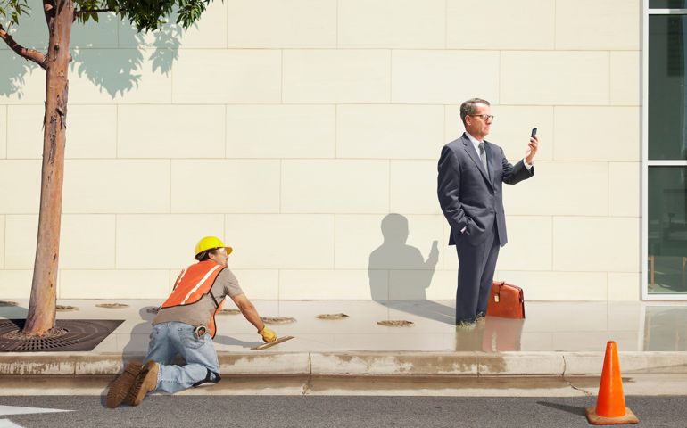Distracted businessman standing in wet cement