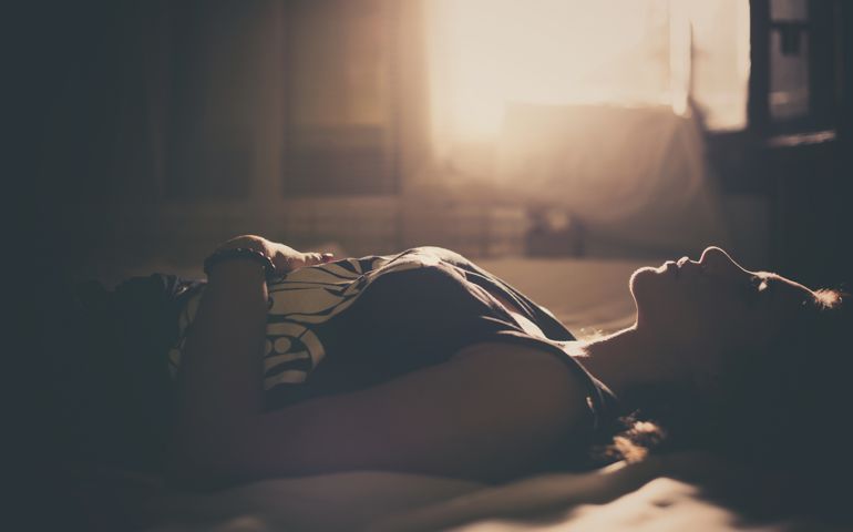 sleeplessness concept - woman laying in bed