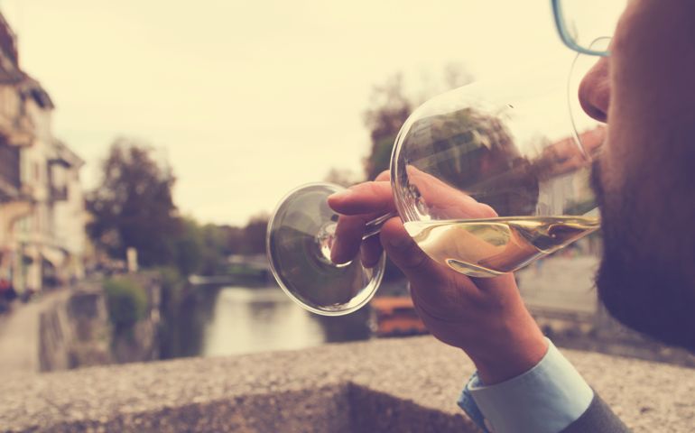 Young man drinking wine outdoors.