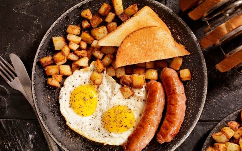 Breakfast with Sunny side up eggs, sausage, hash browns and toast