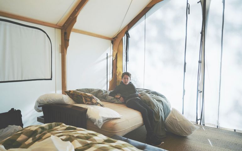 Boy getting ready for the day in his glamping tent