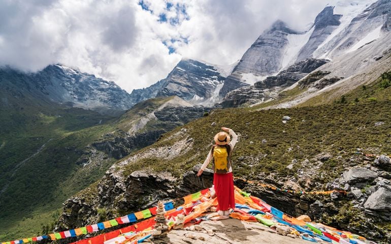 A female traveller was in the canyon,Daocheng County, Sichuan province, China.