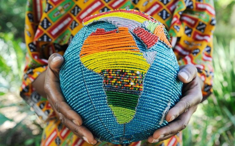 Woman holding a beaded globe with africa showing