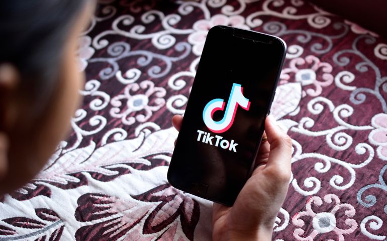 Woman holding motorola phone with ban streaming service media and video TikTok application on the screen.
