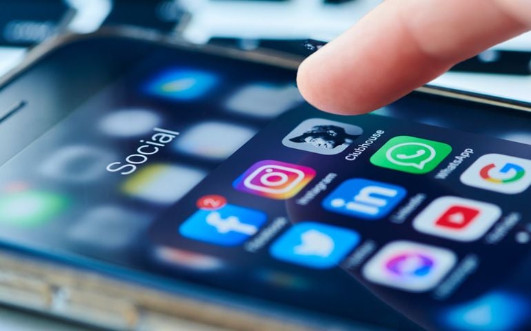 clubhouse app icon on smartphone screen surrounded by other social media apps