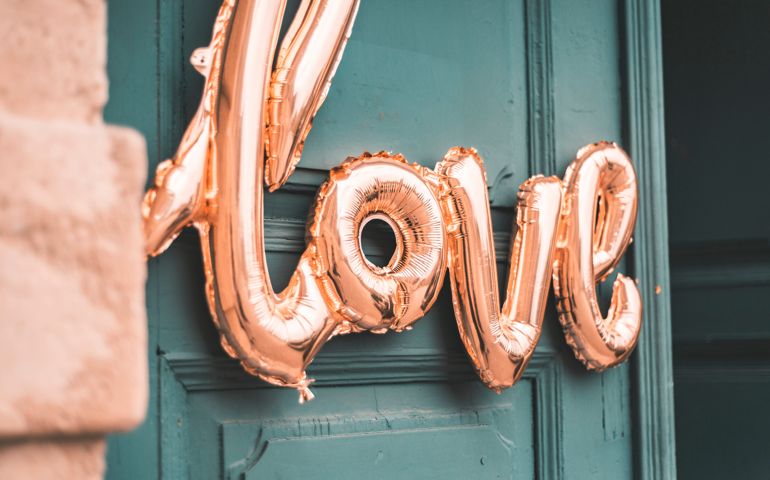 Love shaped balloons in front of wooden door, wedding theme