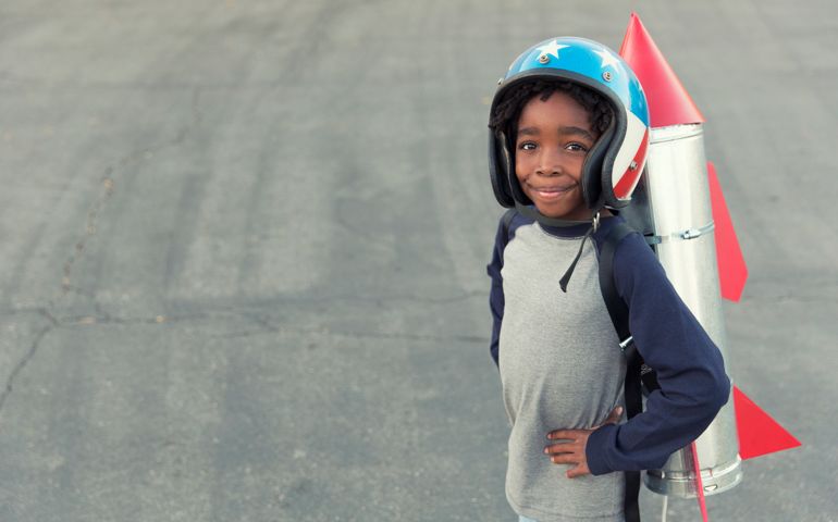 A young African American boy is ready to take to the skies with his new rocket.