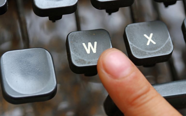 child press the W key symbol of the victory of an ancient mechanical typewriter