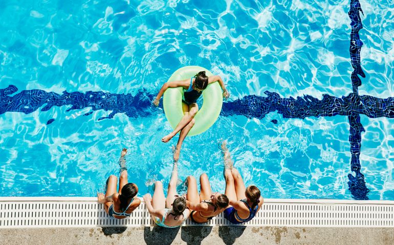 Overhead view of girls hanging out together at outdoor pool