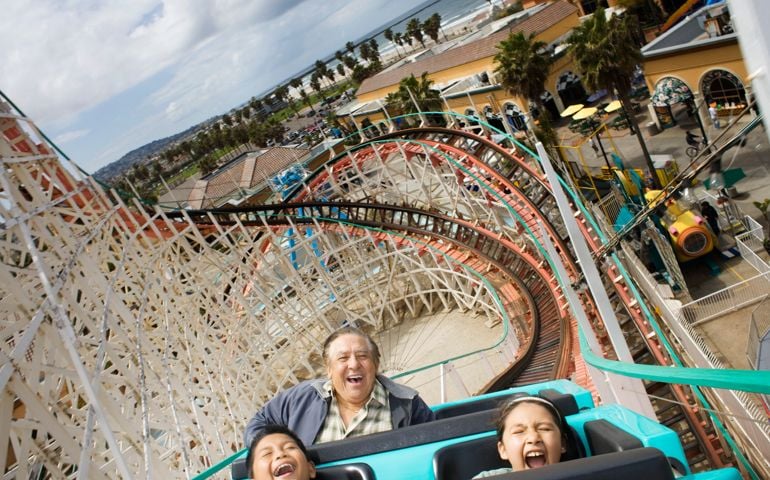 Grandfather and grandchildren (9-11) riding rollercoaster