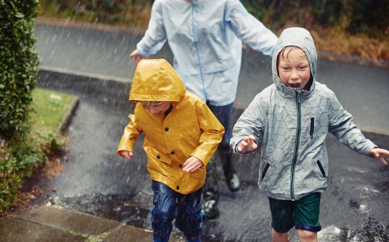 Family running home in the rain
