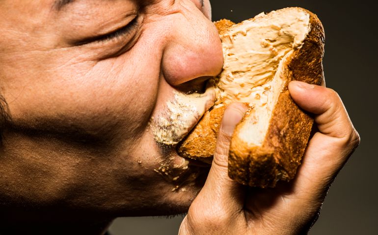 Mid adult man eating peanut butter toast,close up shot