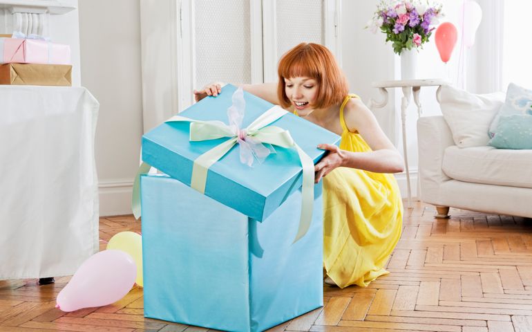 Woman opening large present.
