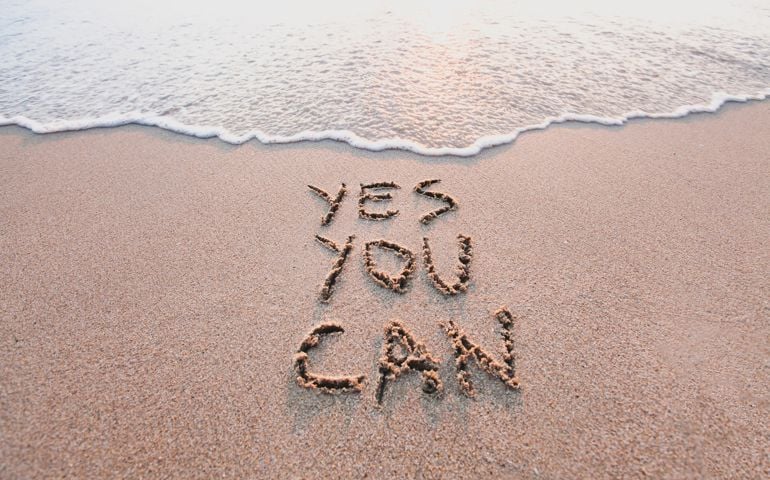 yes you can, motivational inspirational message concept written on the sand of beach