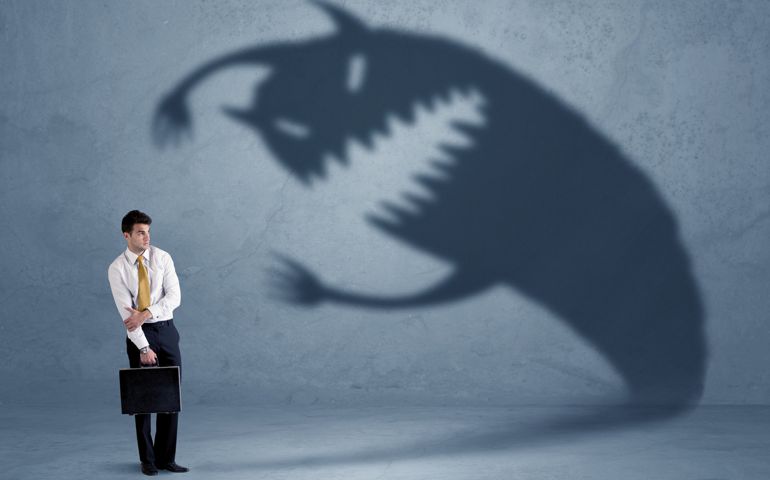 Business man afraid of his own shadow monster concept on grungy background