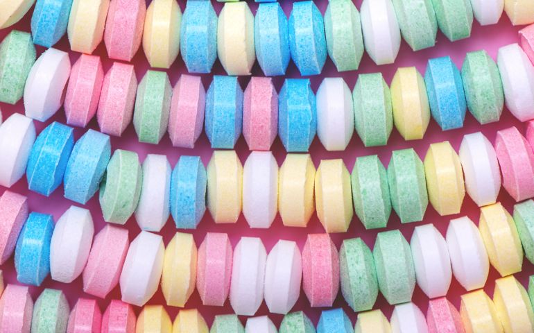 Pastel background made of multicolored candy necklace.