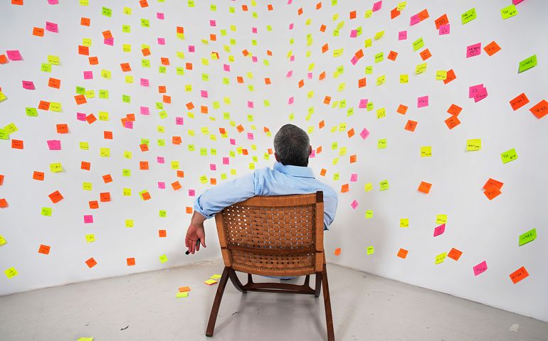 man siting in front of post it notes on the wall