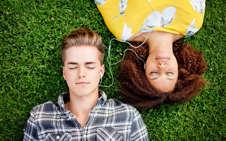Young couple listening to and sharing music.
