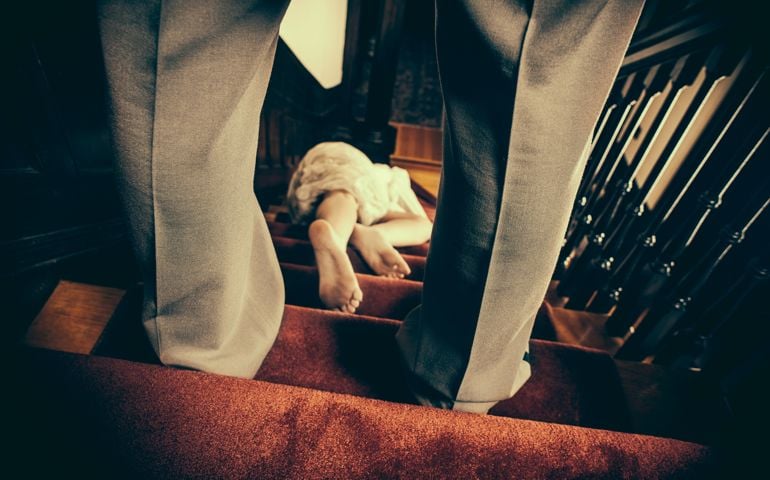 Woman laying on the stairs with a man standing above her
