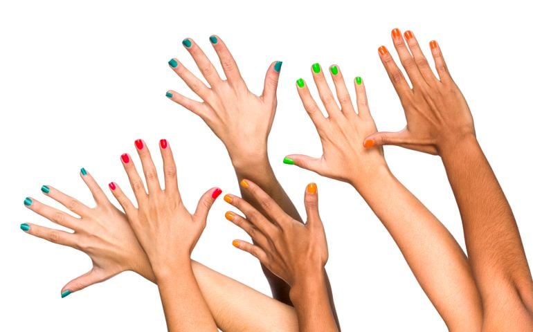 Group of raised multiethnics female hands with colored manicure. Isolated on white with clipping path.