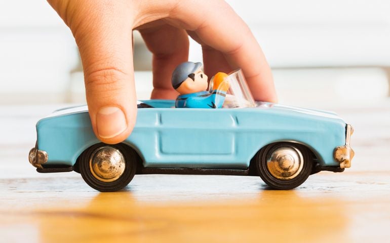 Hand pushing vintage blue toy convertible car