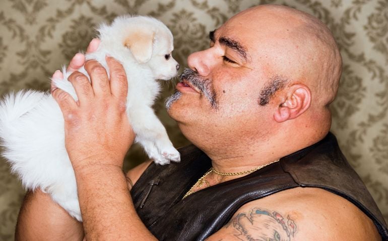 Tattooed Man Cuddling With a Puppy
