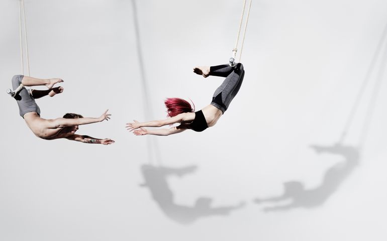 Circus artists in Trapeze, Photographed on white, with shadow projected on the wall