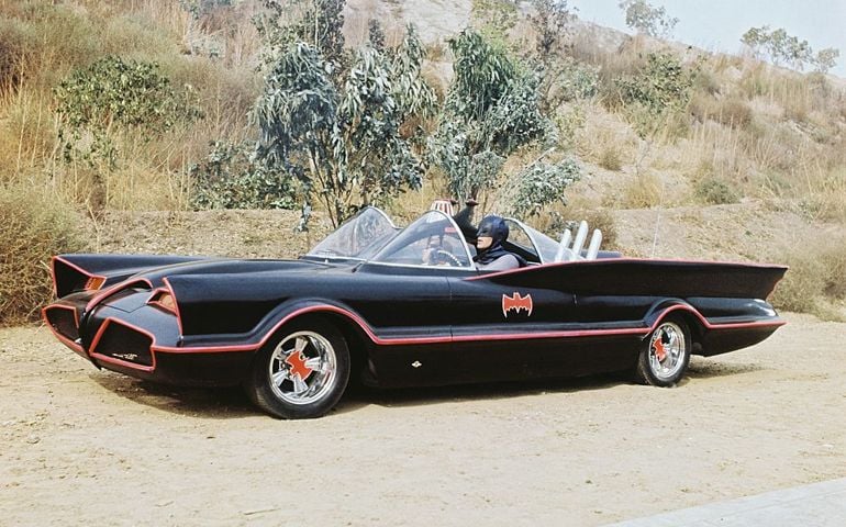 American actor Adam West as Bruce Wayne/Batman at the wheel of the Batmobile with passenger Burt Ward as Dick Grayson/Robin in the TV series 'Batman', circa 1966. The Batmobile was a modified version of the 1955 Lincoln Futura concept car. (